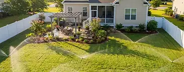 Cane Bay backyard with a newly installed underground irrigation sprinkler system watering a fresh green lawn in South Carolina