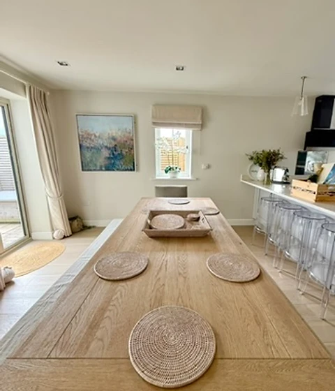 Dining table with woven placemats beside the kitchen peninsula