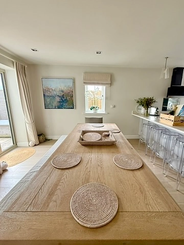 Dining table with woven placemats beside the kitchen peninsula
