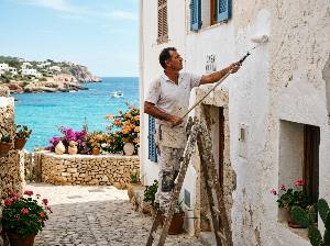 Pintor profesional pintando la fachada de una casa en Ibiza