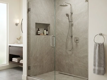 Finished ceramic tile walk-in shower with built-in niche and glass door