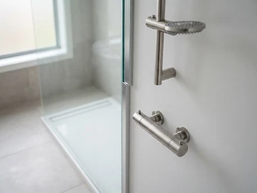 Finished custom acrylic shower with chrome fixtures and glass enclosure