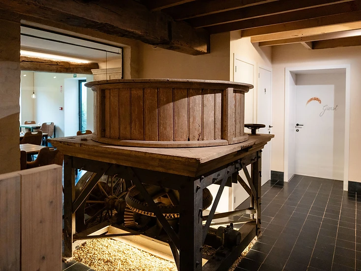 Het oude maalwerk in de molen, met zicht op de warme zaal