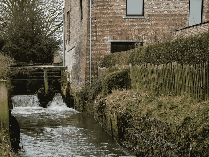 De bakstenen watermolen met de waterval op de beek