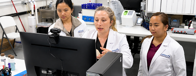 Three Cadence staff members reviewing results around a monitor