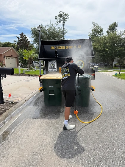 High-pressure hot-water nozzle cleaning the interior of a trash bin