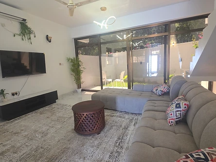 Living room — grey L-shaped sectional, TV and patio doors