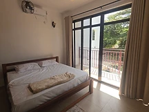 Double bedroom — white linens with balcony view