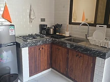 Kitchen — L-shaped counter with fridge and gas cooktop