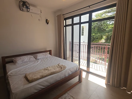 Double bedroom — wooden bed, balcony and air-conditioning