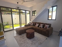 Living room — brown sectional with patio doors to the garden