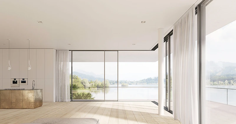 Light-filled living space opening onto a terrace and lake through minimal-frame sliding glass doors