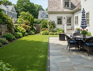 Artificial turf lawn meeting stone paver patio