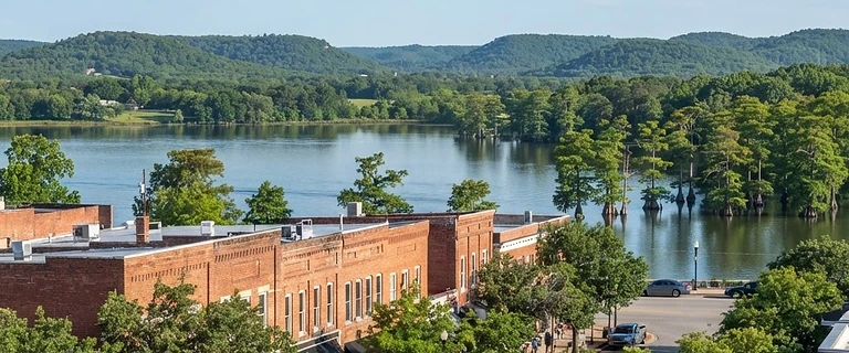 Downtown Conway, Arkansas with brick storefronts and a lakeside view beyond