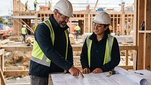 Construction team reviewing building plans on site
