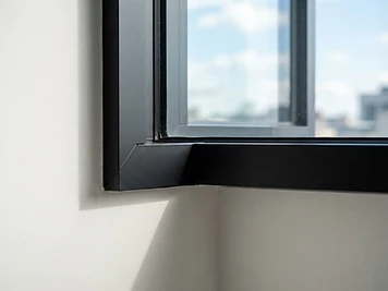 Detalle de esquina de ventana corrediza de aluminio con vidrio claro