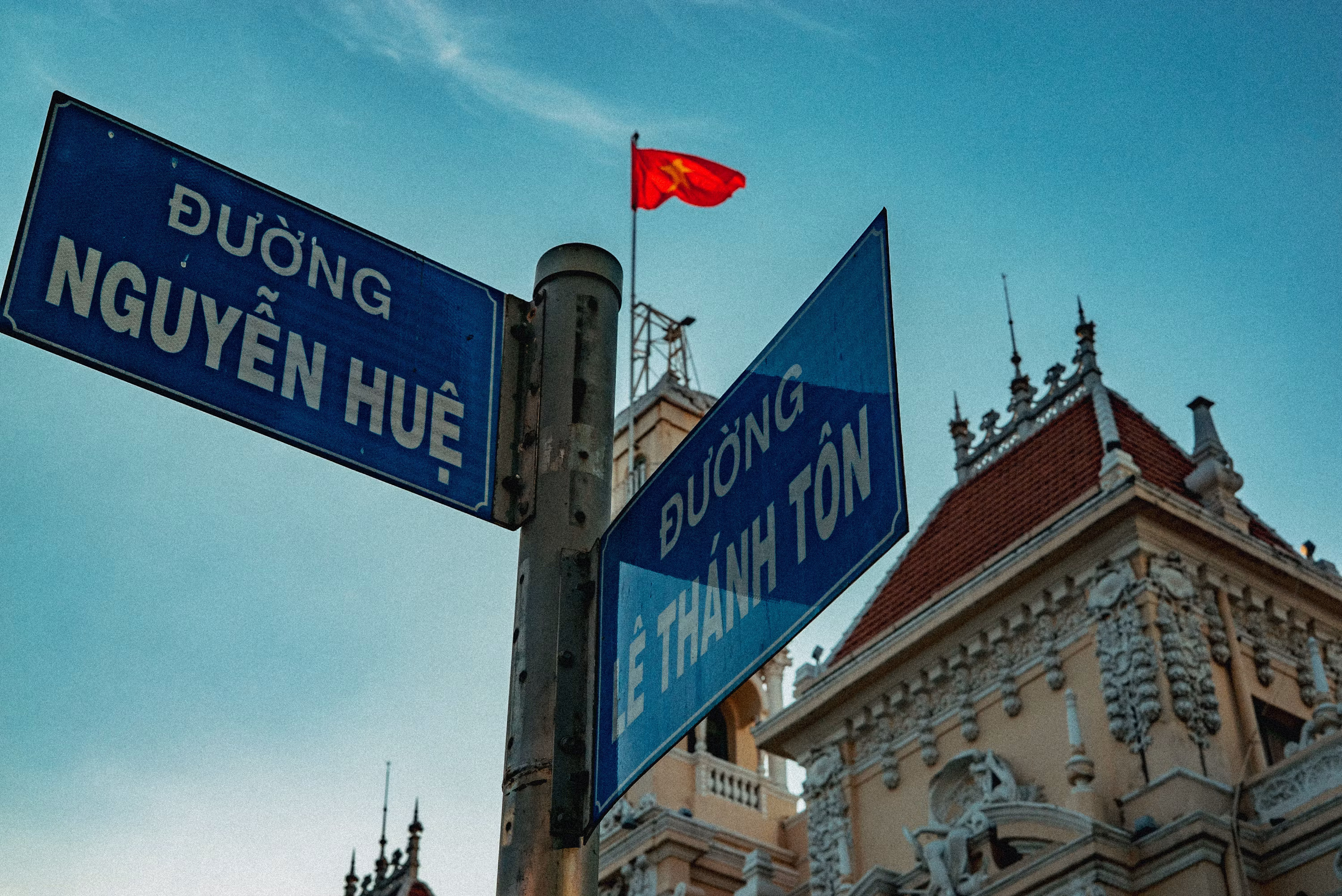 Vietnamese street name signs showing Duong Nguyen Hue and Duong Le Thanh Ton in Ho Chi Minh City