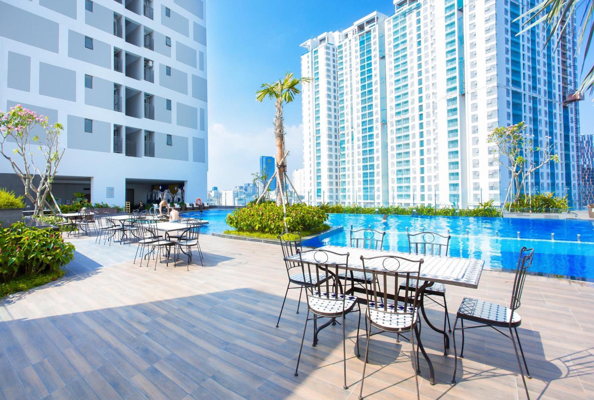 Rooftop swimming pool and outdoor dining area at a modern high-rise apartment complex in Vietnam, showing the amenities available to foreigners renting condos