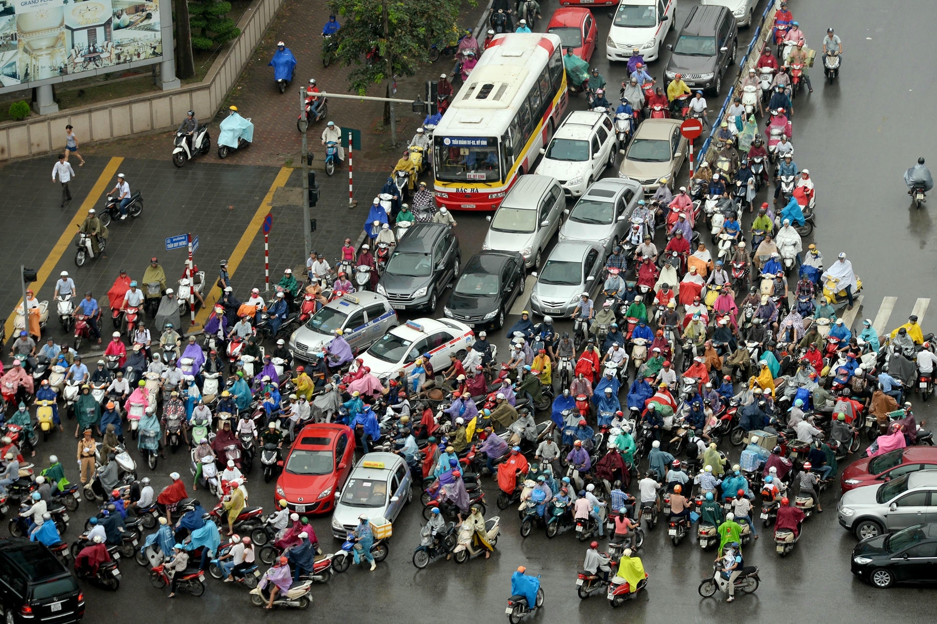 Dense motorbike and car traffic during heavy rain on a Vietnamese street