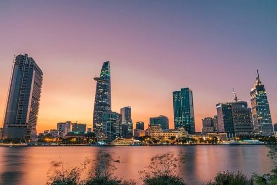 Ho Chi Minh City skyline at dusk with the Bitexco Financial Tower visible across the river, showing the modern urban landscape where many foreigners rent apartments in Vietnam