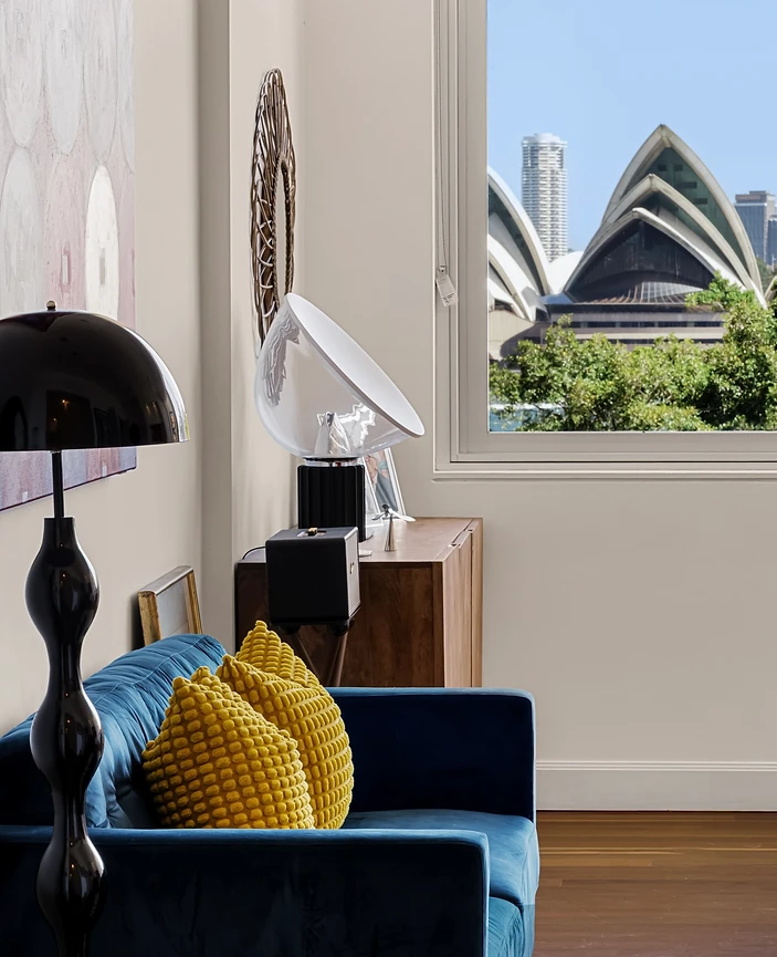 Styled interior with a deep blue sofa and Sydney Opera House view