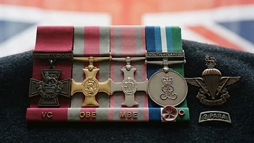 Realistic illustration of the military medals and badges awarded to H. Jones, including Victoria Cross, Officer of the Order of the British Empire, Member of the Order of the British Empire, South Atlantic Medal, shown against a light United Kingdom flag background. AI-generated illustration, not an authentic photograph.