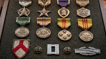 Realistic illustration of the military medals and badges awarded to Michael Vicelleo, shown against a light Vietnam flag background. AI-generated illustration, not an authentic photograph.
