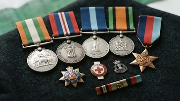 Realistic illustration of the military medals and badges awarded to Amiya Nath Bose, shown against a light India flag background. AI-generated illustration, not an authentic photograph.
