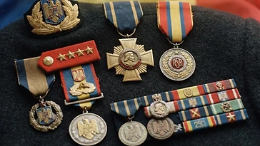 Realistic illustration of the military medals and badges awarded to Dumitru Iliescu, including Order of Tudor Vladimirescu, Emblem of Honor of the Romanian Armed Forces, shown against a light Romania flag background. AI-generated illustration, not an authentic photograph.