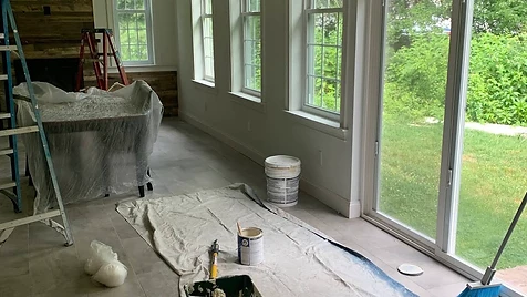 Interior Living Space — Floors and furniture protected while walls and ceilings receive a crisp off-white finish around the wood accent wall.