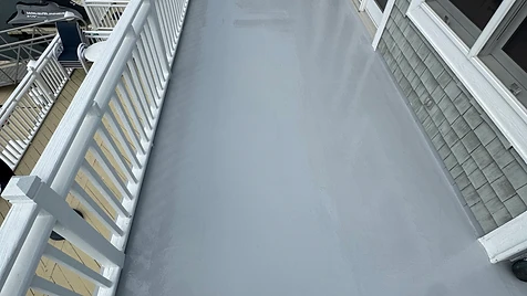 Balcony Deck — Finished — A smooth, uniform deck coating cured to perfection — Marina views intact and railing lines razor-sharp.