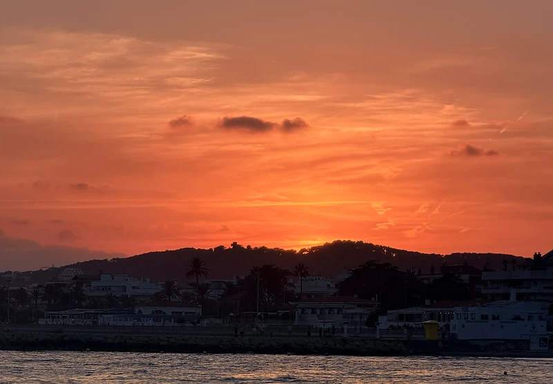 A bright golden sky over a calm horizon at sunset