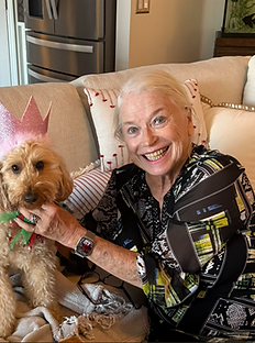 January Jones with Ginger Ale wearing a party crown on the sofa