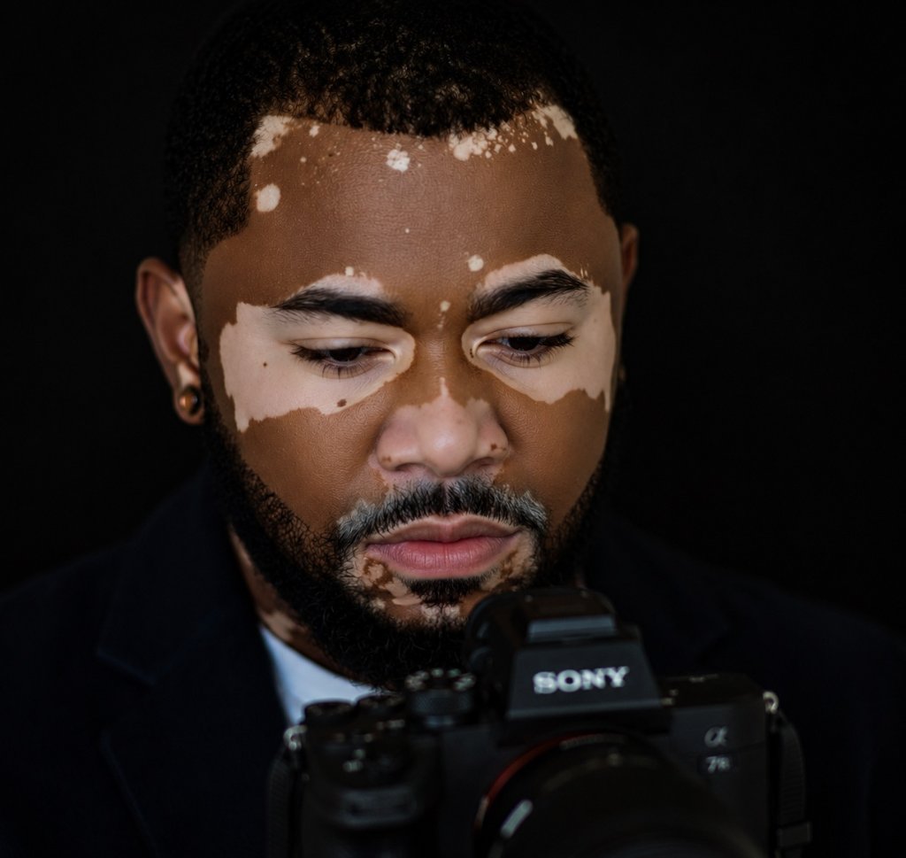 Cinematic close-up portrait of the photographer in soft, moody studio light