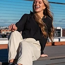 Woman laughing on a wooden deck in late afternoon sun