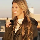 Woman holding a lavalier microphone in golden-hour light