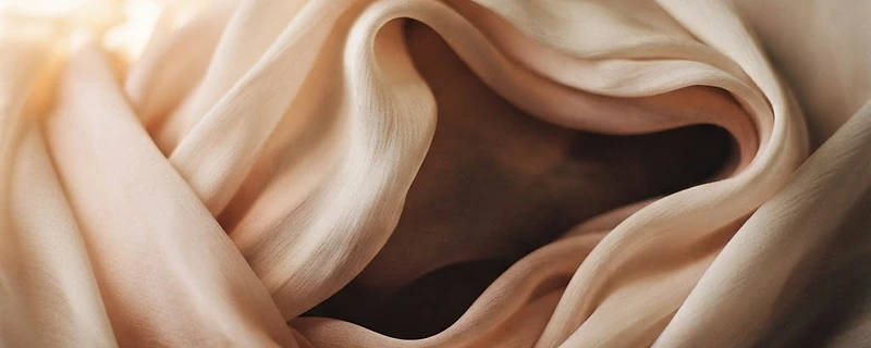 Soft folds of cream and blush silk in warm golden light
