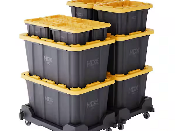 Stack of heavy-duty black moving boxes with bright yellow snap-fit lids on rolling dollies