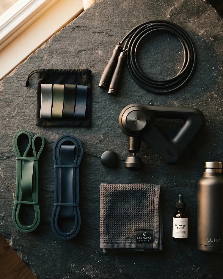 Premium training and recovery gear arranged on dark stone