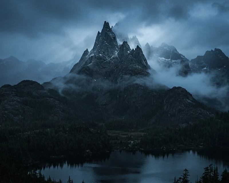 Nebliger Berggipfel in der blauen Stunde