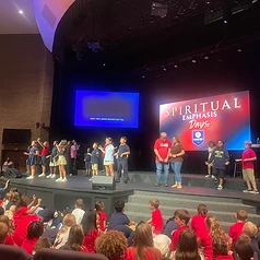 Spiritual Emphasis Days stage with youth and audience in red shirts