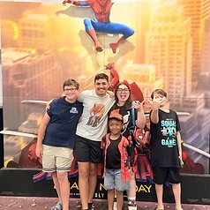 Five kids posing with the Spider-Man movie standee