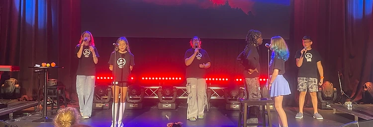 Youth singing together on stage during a worship service