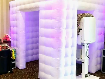 Guests posing with a white party cube at the photo booth