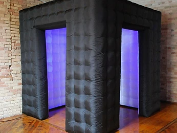 A guest posing on a black party cube at the photo booth