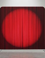 A red velvet curtain backdrop with a dramatic spotlight glow