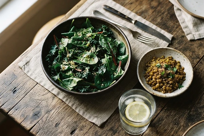 A balanced meal of greens and lentils on a wooden table.