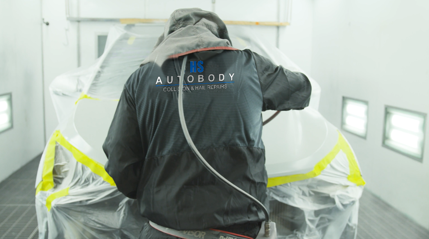 HS Autobody technician spray painting inside the spray booth