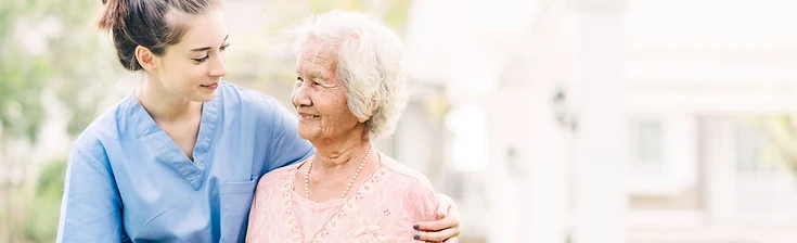 A caregiver and elderly woman sharing a warm moment