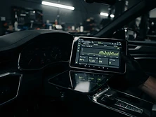 Diagnostic tablet displaying a clean interface reflected in a car dashboard